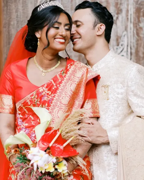 A bride in a red sari with her groom
