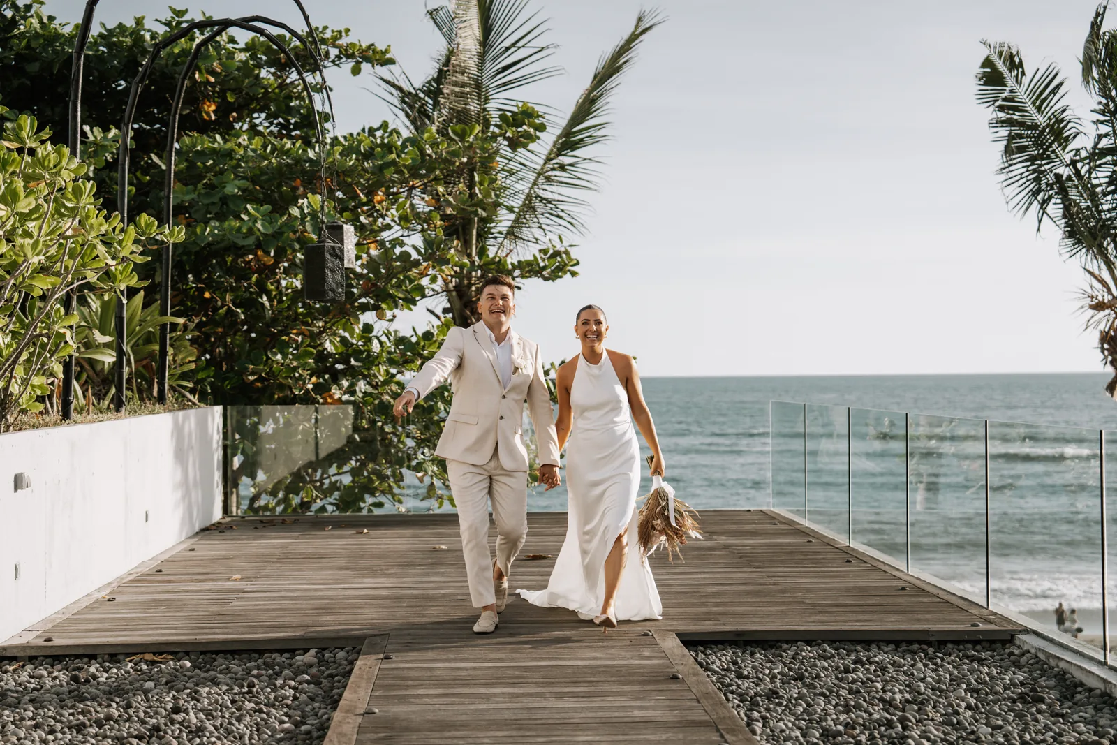 A couple walking the deck at Arnalaya Beach House above the surf