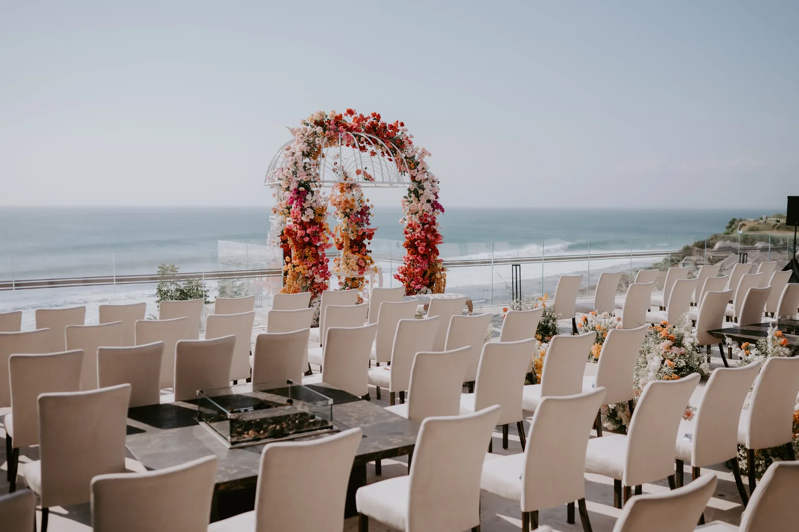 Chairs set for a clifftop ceremony at Jumeirah Bali, the floral arch facing the sea