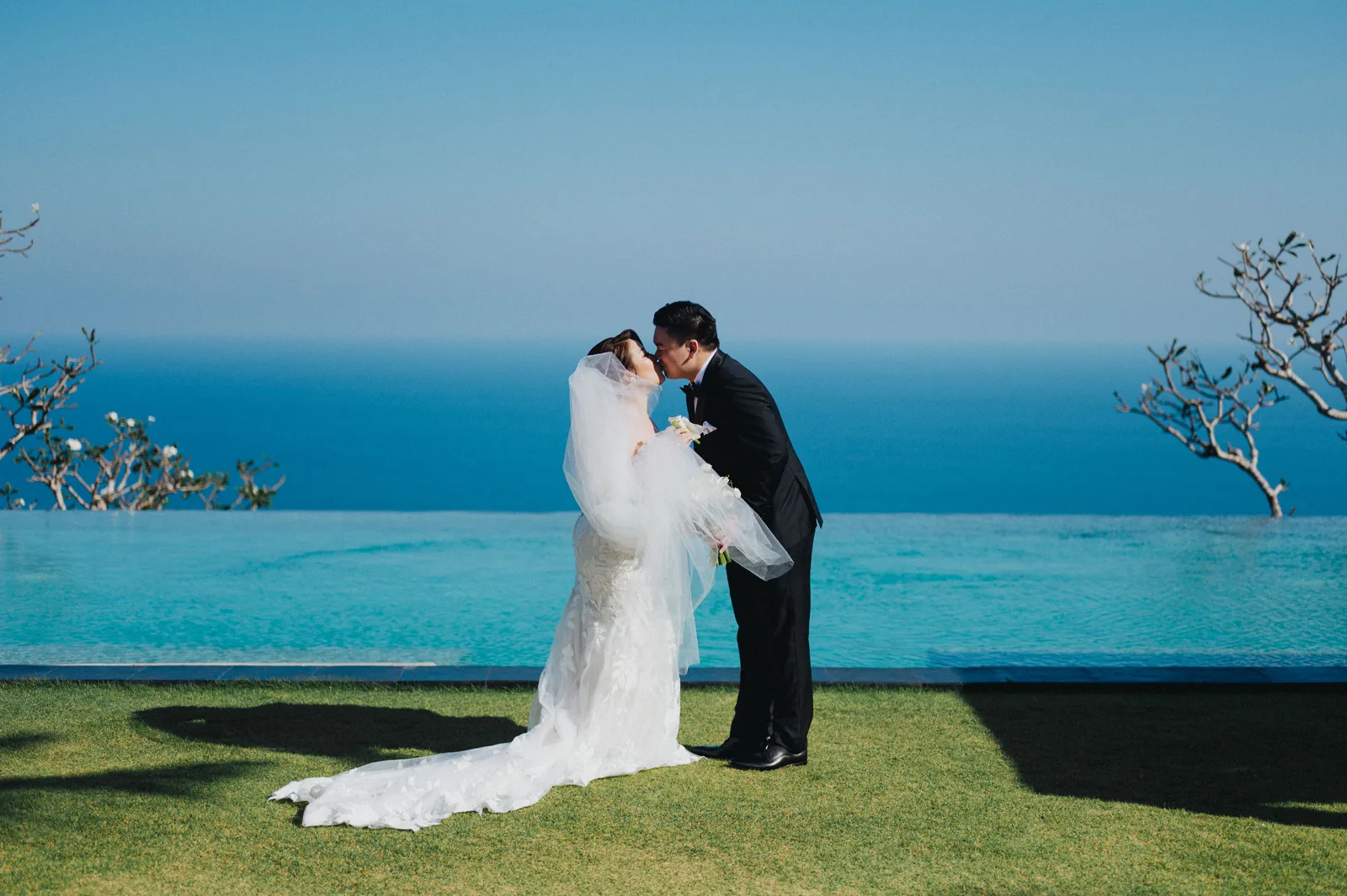 A couple together on the clifftop at Khayangan Estate, the Indian Ocean beyond