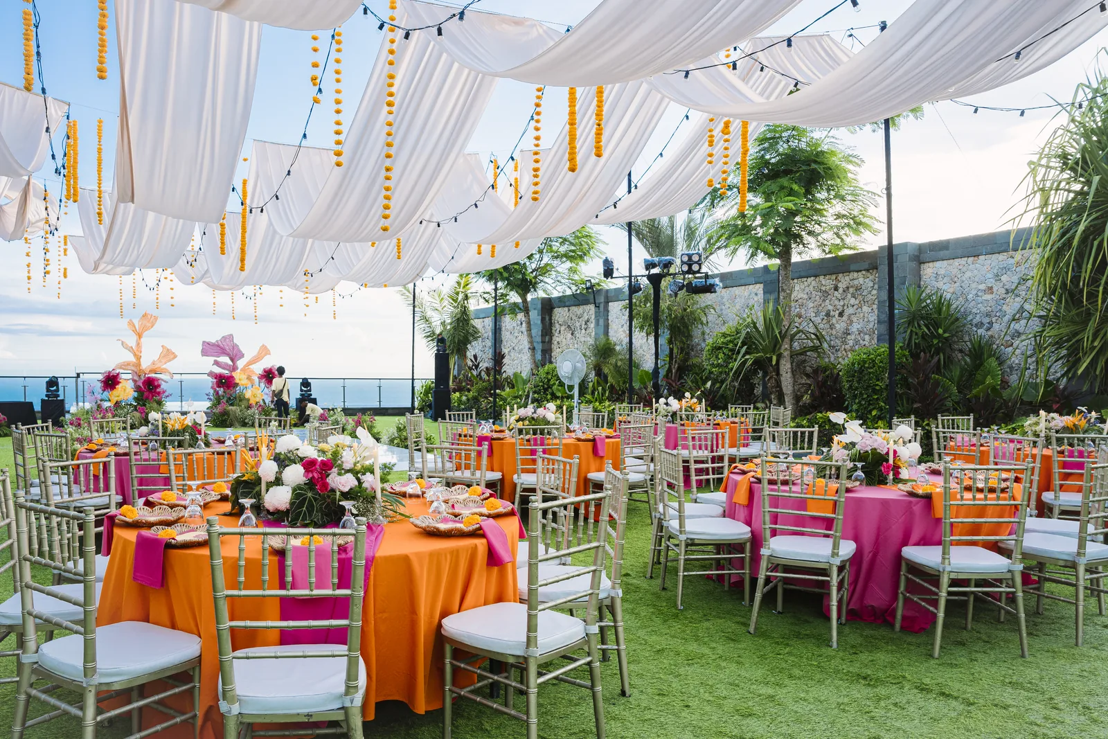 A reception laid under draped canopies at Stones Villas Uluwatu, the ocean on the horizon