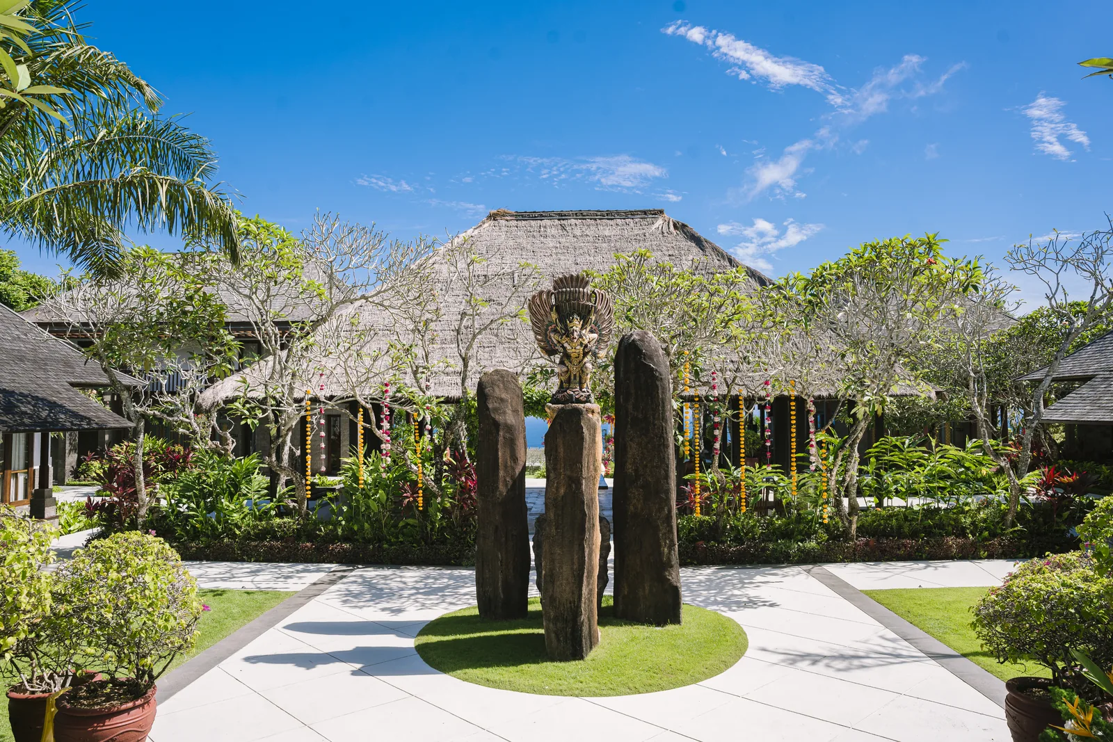 The arrival courtyard at Stones Villas Uluwatu, thatched pavilions set among the gardens