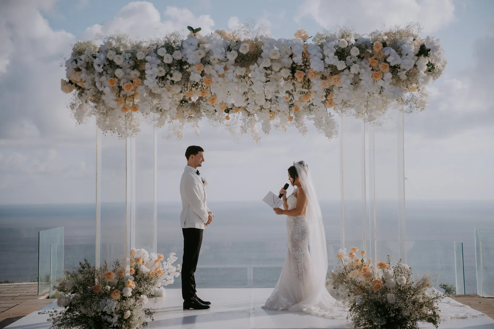 The floral canopy and altar at Villa Plenilunio set against open sky and ocean
